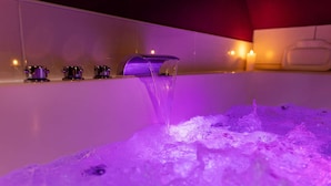 Eine Badewanne mit Wasserhahn, umgeben von einer violett beleuchteten Umgebung.