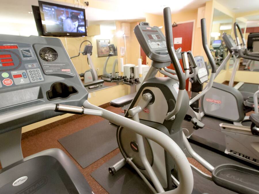A gym with various exercise machines, including treadmills and an elliptical.
