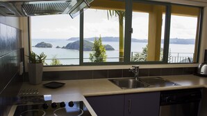Una cocina con vista al mar, que incluye estufa, fregadero y lavavajillas.