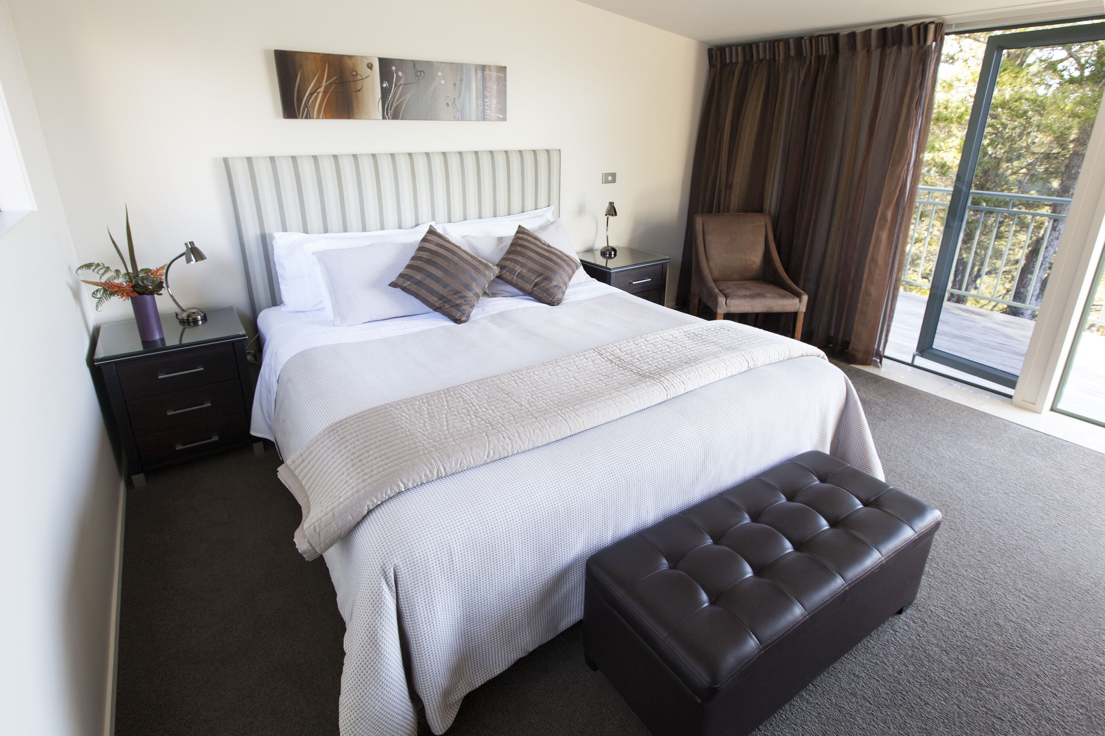 Habitación de hotel impecable con una cama grande, zona de estar y vistas por la ventana.