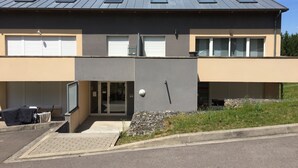 A modern two-story building with a flat roof, large windows, and a garage entrance. - Luxury apartment (Apach)