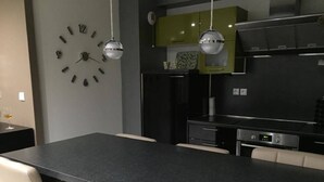 A modern kitchen with a central island, stainless steel appliances, and pendant lighting. - Luxury apartment (Apach)