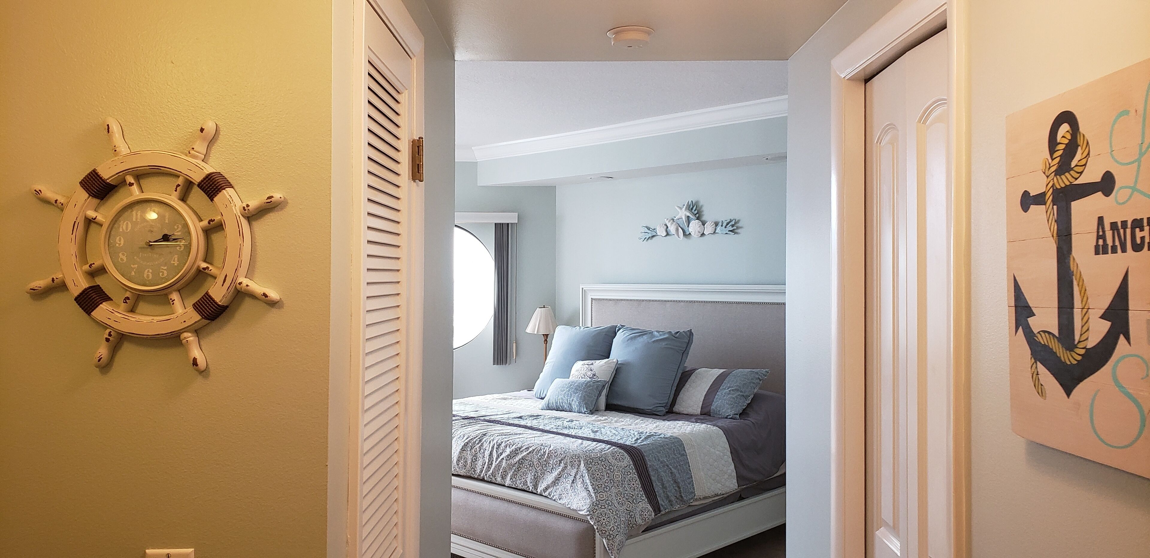 Un dormitorio con cama, un reloj de pared y decoración temática náutica.