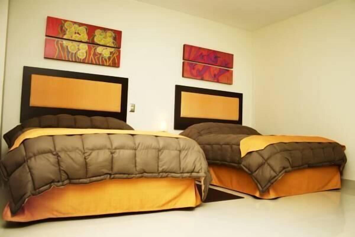 Une chambre d’hôtel avec deux lits, chacun doté d’une tête de lit et d’un pied de lit assorti.