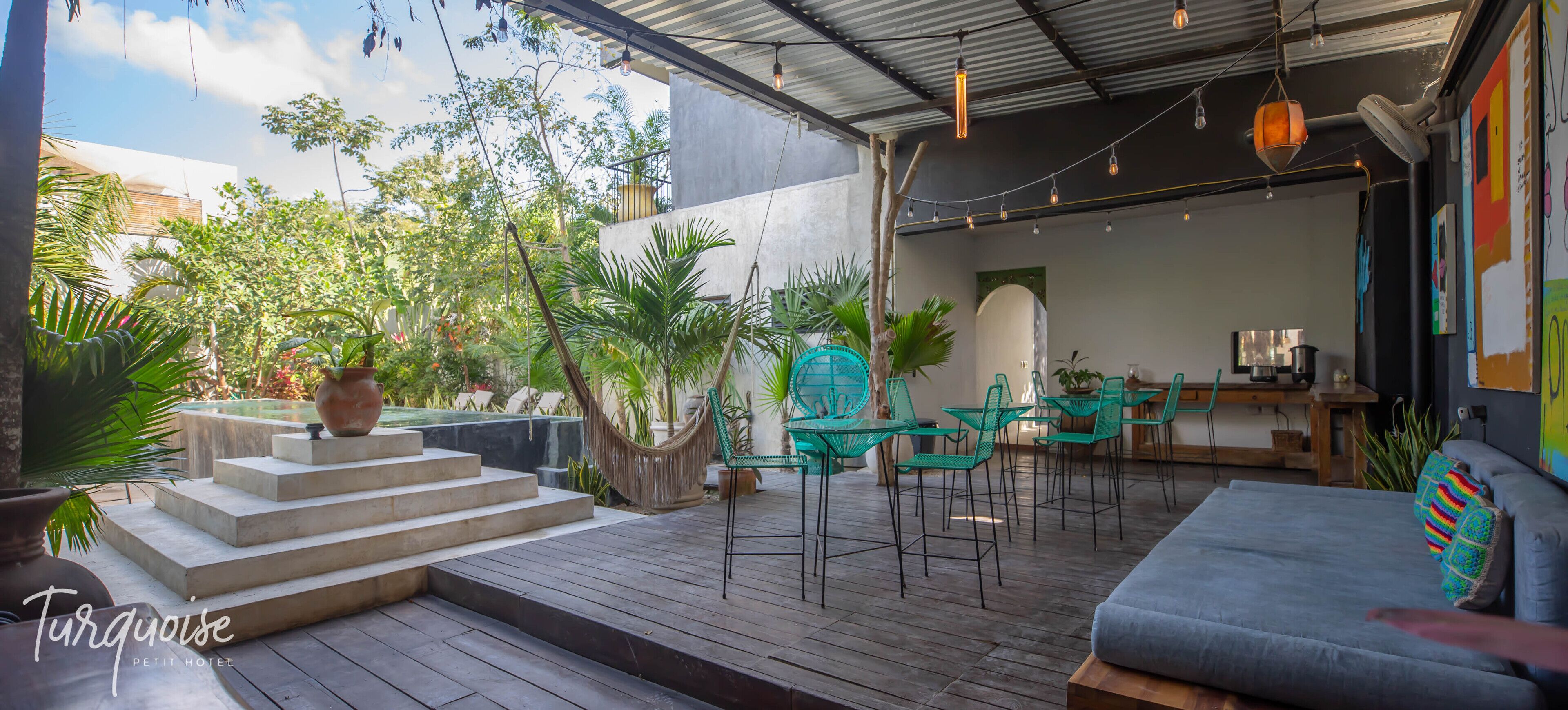 A terrace with a sofa, chairs, and a dining area with a table and chairs.