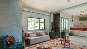 A spacious living room with a sofa, a coffee table, and a colorful rug.