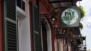 Une rangée de bâtiments aux volets verts, avec une enseigne indiquant le restaurant « Pat O’Brien’s ».
