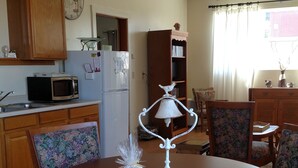 A dining area with a round table, floral-patterned chairs, a white table lamp, and a clock on the wall. - The Garden Suite has beautiful views of forests and pastures! It is dog friendly (Ferndale)