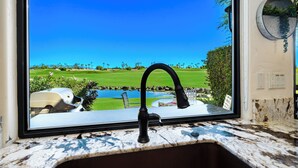 A kitchen with a sink and a window overlooking a golf course. - Stay Where the Legends Play - Front Row Fairway Views at PGA West Stadium (La Quinta)