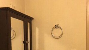 Une salle de bain avec un lavabo blanc, un miroir et des toilettes.