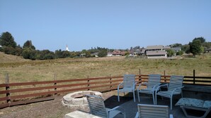 A park with a wooden fence, outdoor seating, and a distant church.