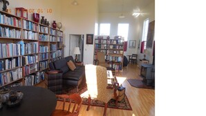 A spacious living room with a large bookshelf, a fireplace, and a cozy seating area.