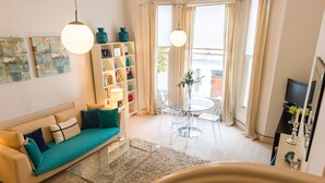 A modern living room with a sofa, glass coffee table, and a bookshelf. - LOCATION LOCATION LOCATION - Prime central London ZONE 1 (London)