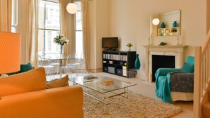 A living room with a glass coffee table, a sofa, a fireplace, and a television. - LOCATION LOCATION LOCATION - Prime central London ZONE 1 (London)