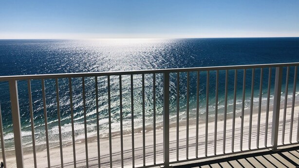 En balkon med udsigt over havet og stranden.