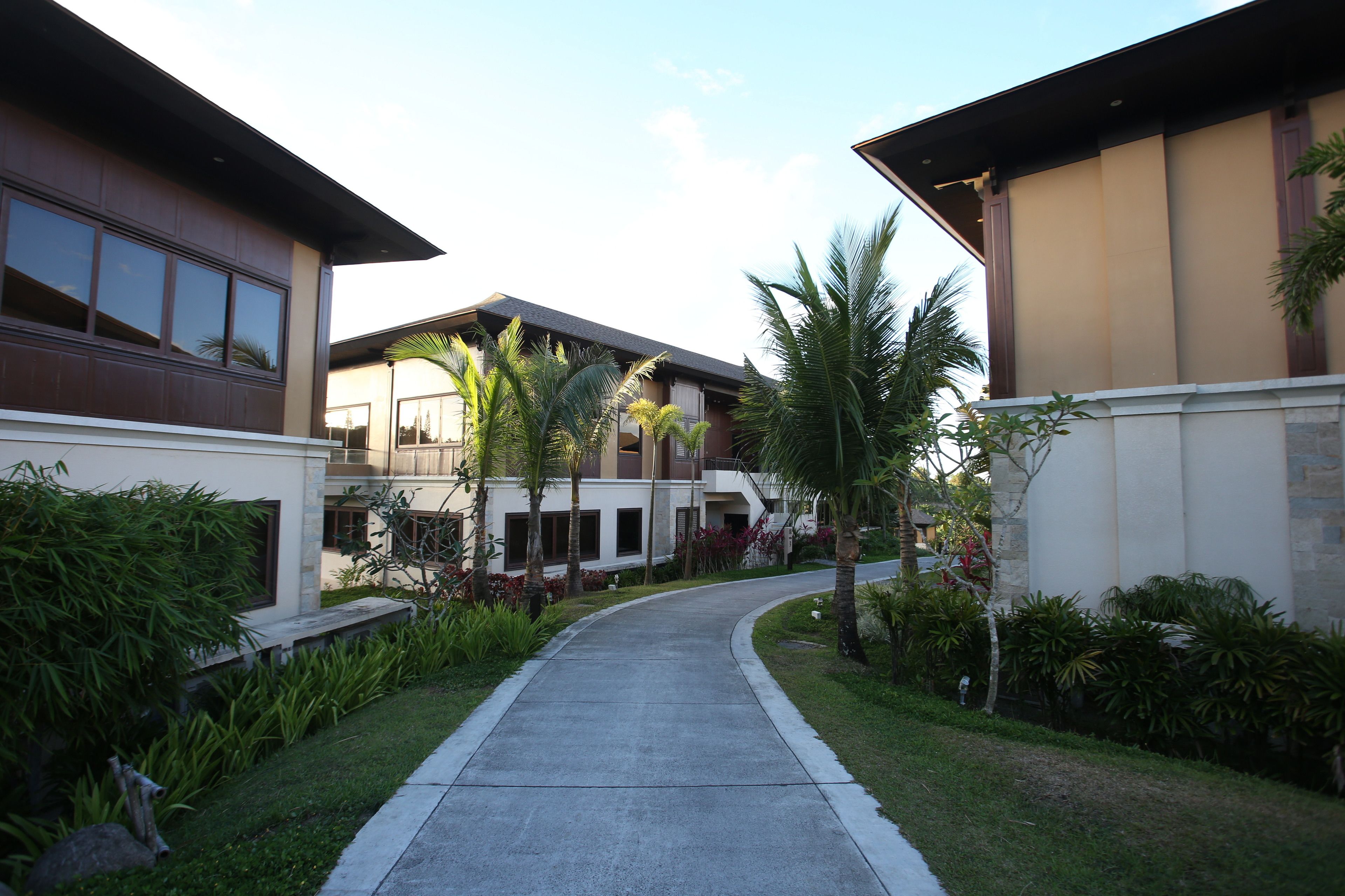 A residential area with modern houses, a curved pathway, and well-maintained greenery.