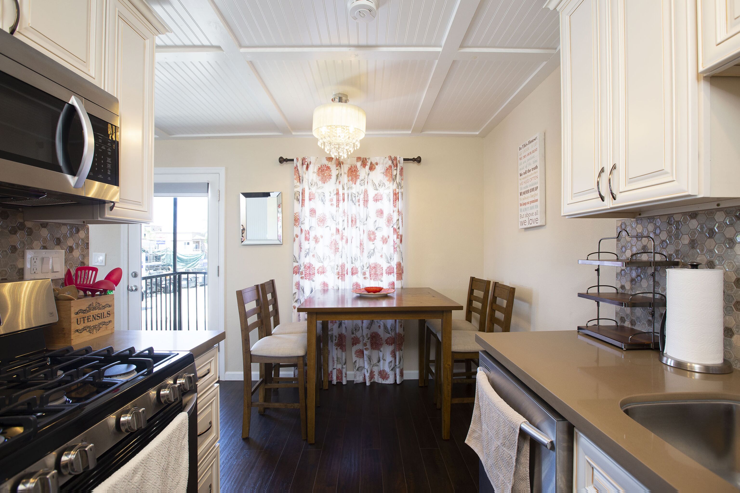 A kitchen with a stove, microwave, and a dining table with chairs.