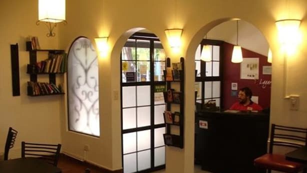 A restaurant interior with a reception desk, a bar area, and a seating section. - Hostel Lagares (Mendoza)