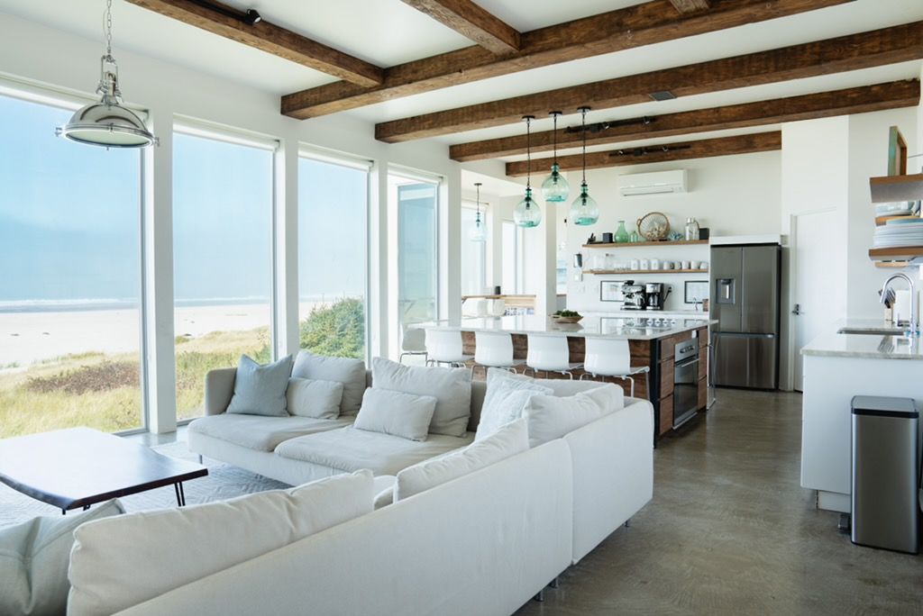 A modern kitchen with a central island, white cabinetry, and stainless steel appliances.