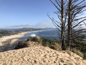 A beach with a clear view of the ocean and distant hills.
