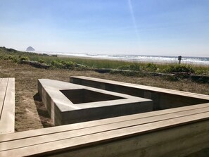 A beach view with a concrete structure and wooden benches.