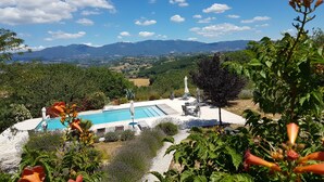 Un espace piscine offrant une vue sur les montagnes et la campagne environnante.