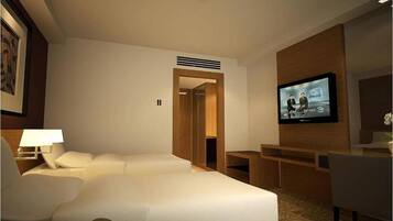 A hotel room with a bed, a desk, a television, and a chair.