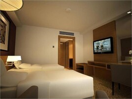 A hotel room with a bed, a desk, a television, and a chair.