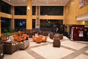 A spacious lobby with multiple seating areas, a large pillar, and a view of the outside through large windows. - Hotel Tenera (Bandar Baru Bangi)