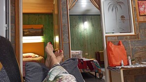 Ein Zimmer mit einem Bett, einem kleinen Tisch und einem Spiegel.