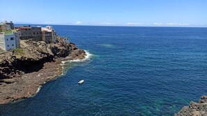 Ein Küstenblick mit Gebäuden auf einem felsigen Klippenhang mit Blick auf das Meer.