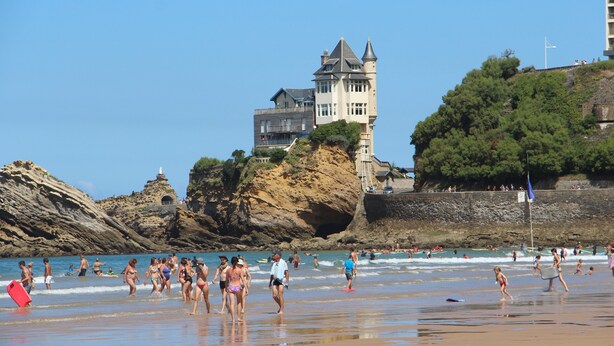 A beach with people, a castle, and a lighthouse. - Biarritz, T2 45 m² near Côte des Basques (Biarritz)