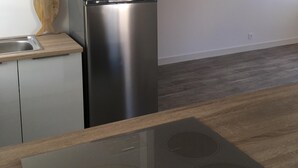 A modern kitchen with a stainless steel refrigerator, a built-in oven, and a wooden countertop. - Sea view from the large beach (Quiberon)