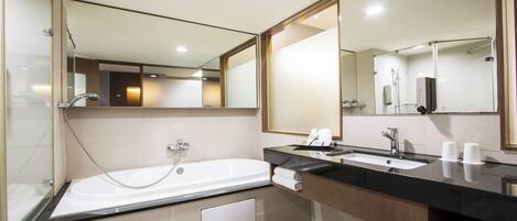 A modern bathroom with a bathtub, a sink, and a large mirror.