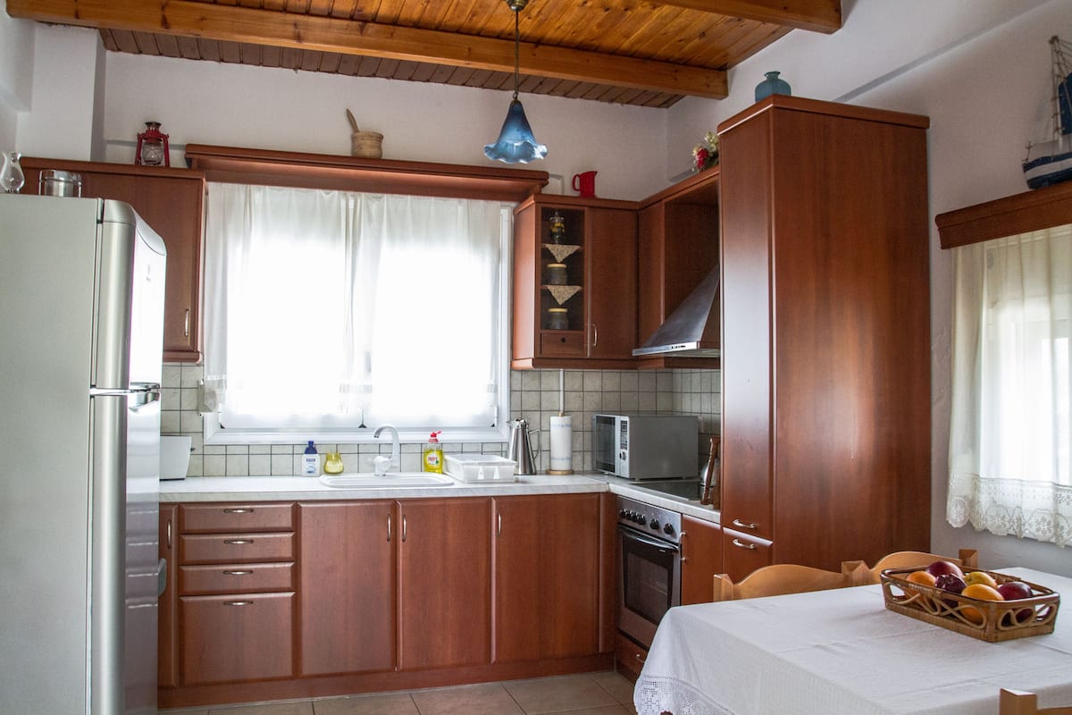 Une cuisine avec des armoires en bois, un réfrigérateur, un four à micro-ondes et une cuisinière.