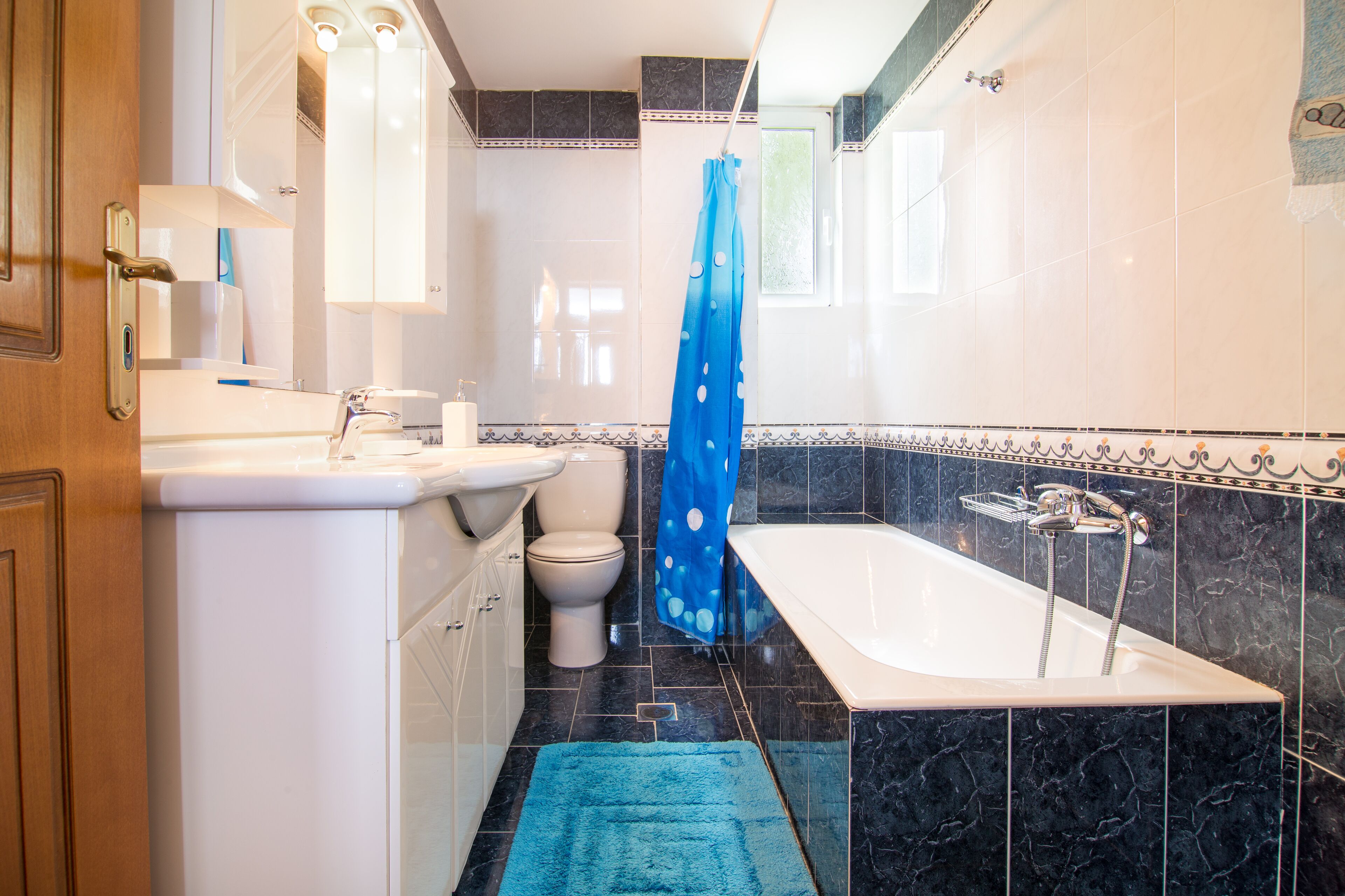 Une salle de bain avec un lavabo, des toilettes et une baignoire, le tout de couleur blanche.