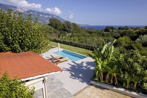 A swimming pool with a red roof, surrounded by lush greenery and a mountain backdrop. - Green retreat ,family friendly , sea view, privacy, picturesque village (spartia)