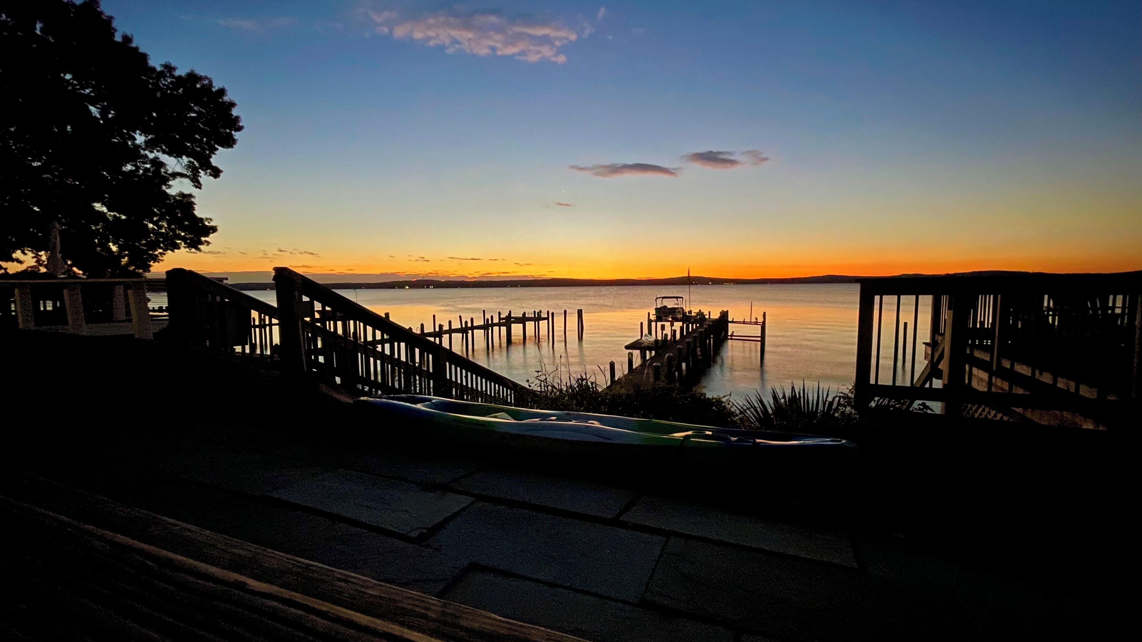 A waterfront view with a dock and a staircase leading to a docked boat.