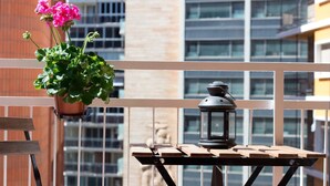 A balcony with a hanging flower pot and a lantern on a wooden table. - APART.RIVERA #3 IN THE OLD TOWN ONLY 10 MINUTES WALKING DISTANCE TO THE BEACH. (Alicante)