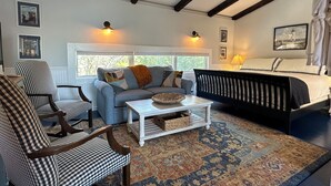 Ein gemütliches Zimmer mit einem Karoknocker, einem Sofa, einem Bett und einem gemusterten Teppich.