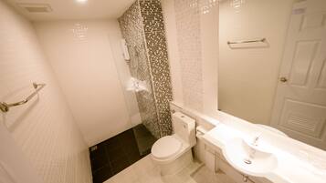 A bathroom with a toilet, sink, and shower.