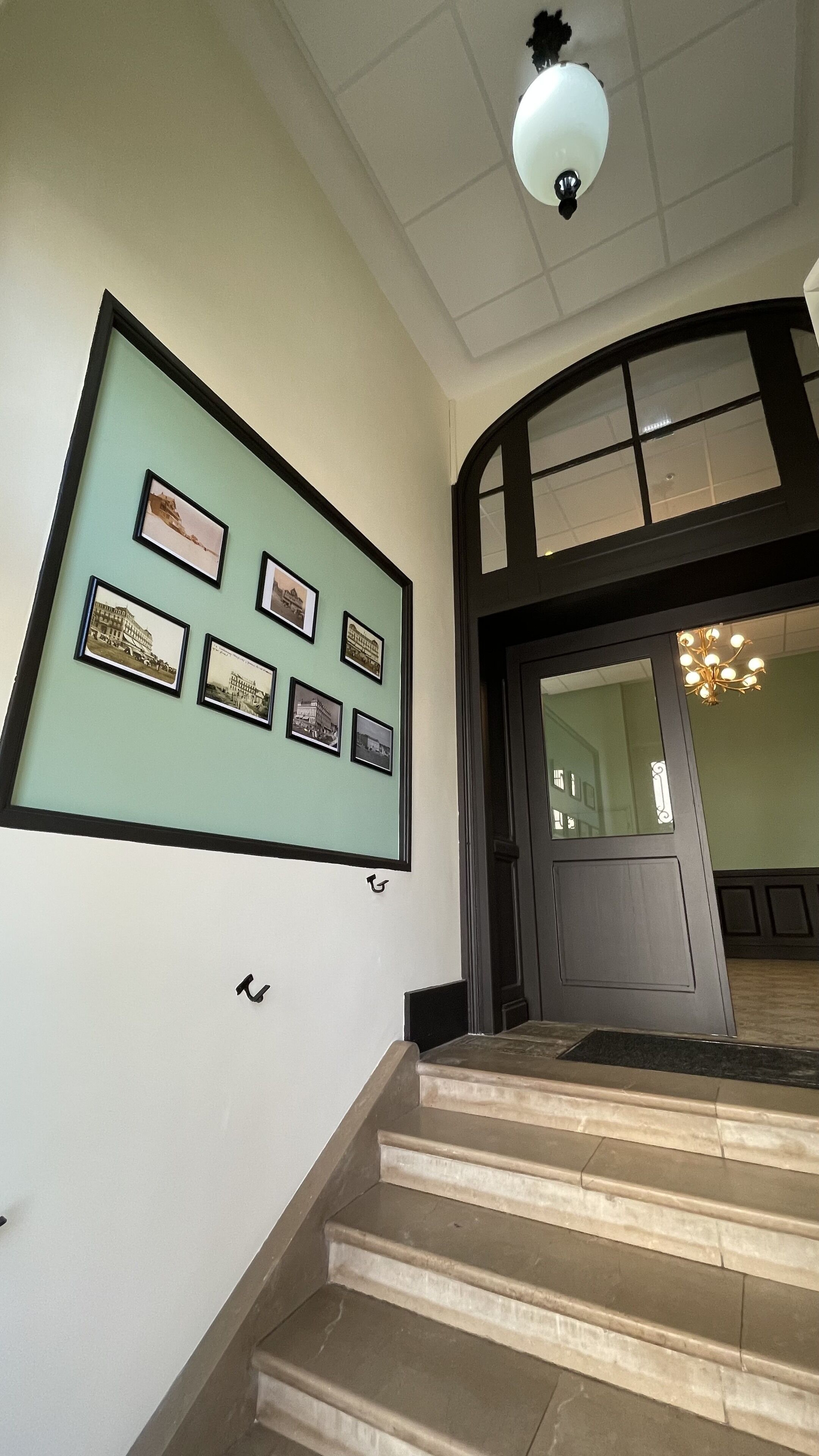 A staircase leading to a room with framed pictures on the wall.