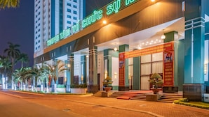 Ein Hotel mit auffälligem Neonzeichen, einer modernen Fassade und einem gut beleuchteten Eingangsbereich.