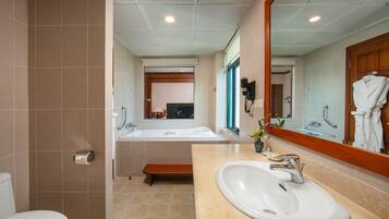 A modern bathroom with a toilet, sink, and bathtub.