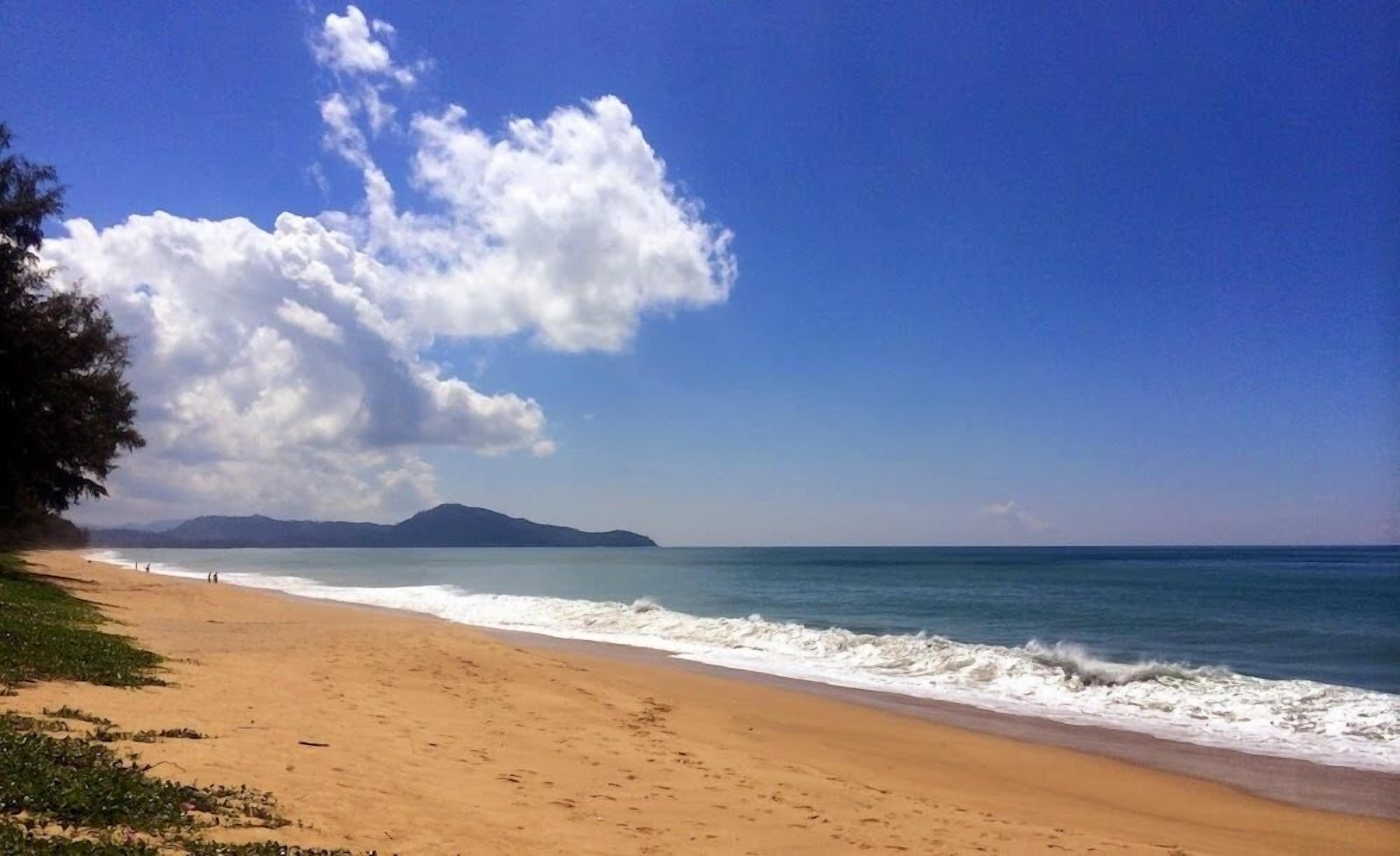 Una playa con cielo despejado y olas.