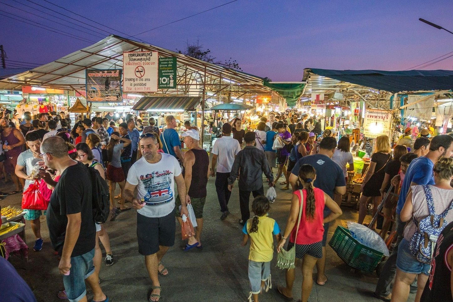 Een drukke markt met mensen die lopen en winkelen.
