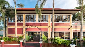 Stunning two-story building with a glass entrance and lush green surroundings.