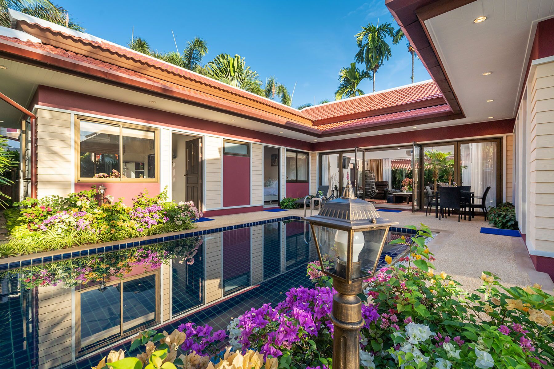 Una casa moderna con piscina, ventanas amplias y un área de patio.