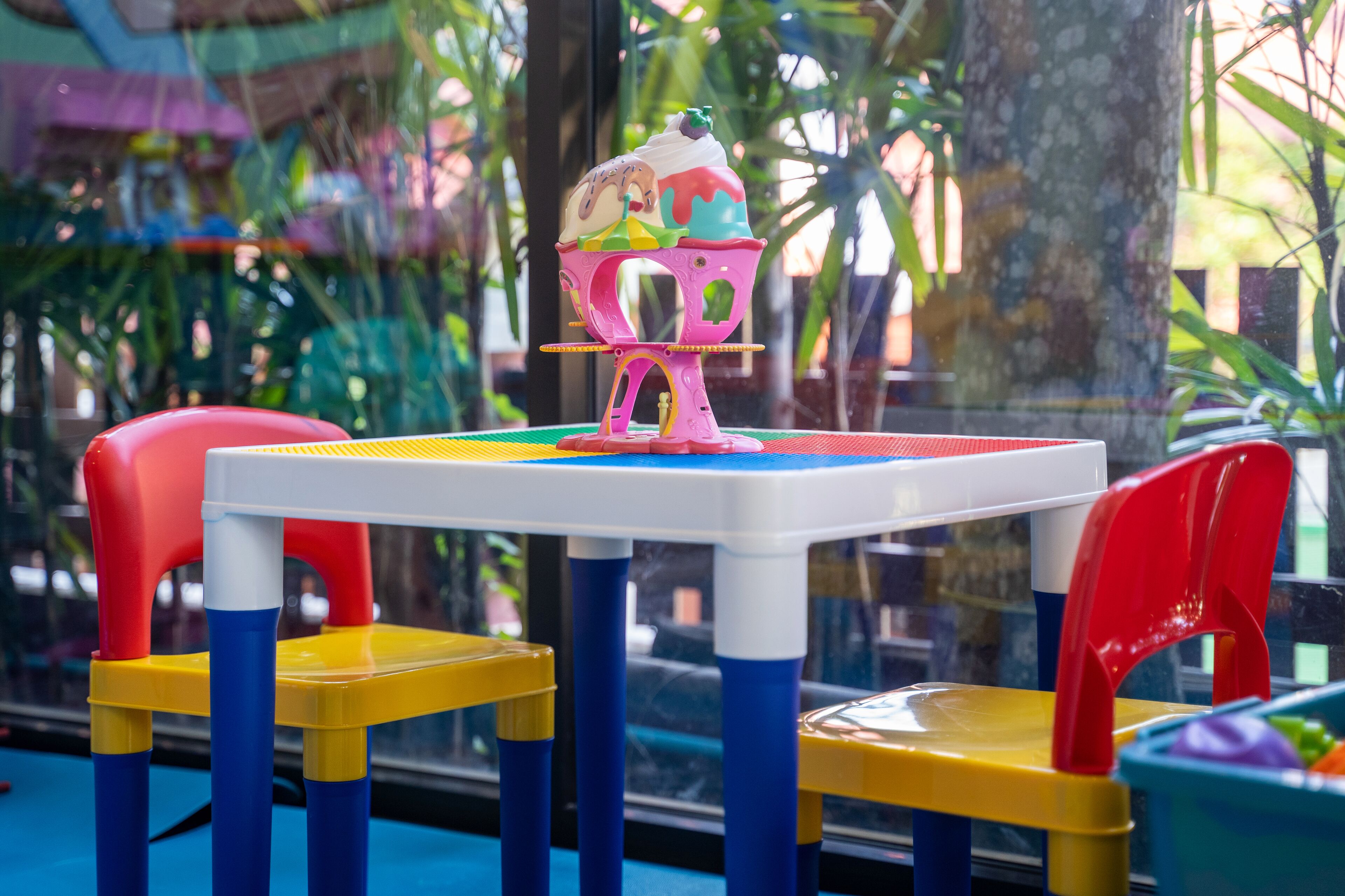 A colorful indoor play area with a table and chairs.