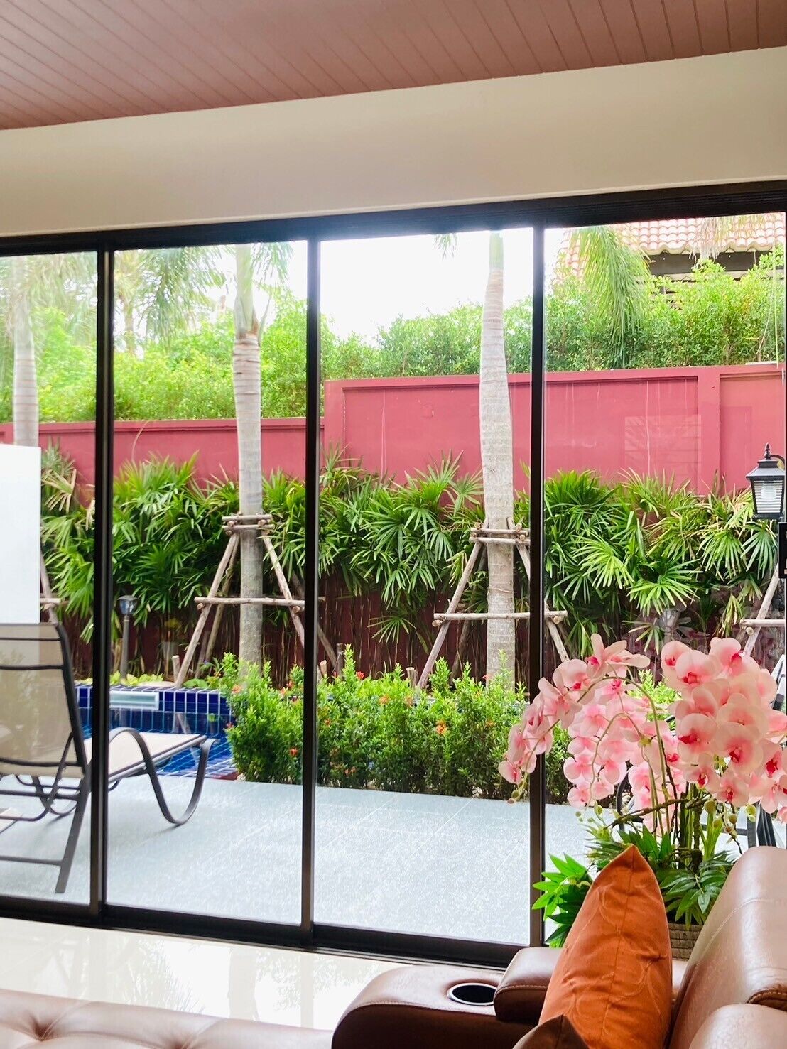 Una sala de estar moderna con un amplio ventanal corredera que da a un jardín.